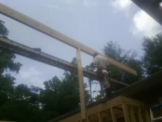 Carpenter setting a ridge beam over a new addition frame — Ice Dam Removal by Roofing Brothers in Dickerson