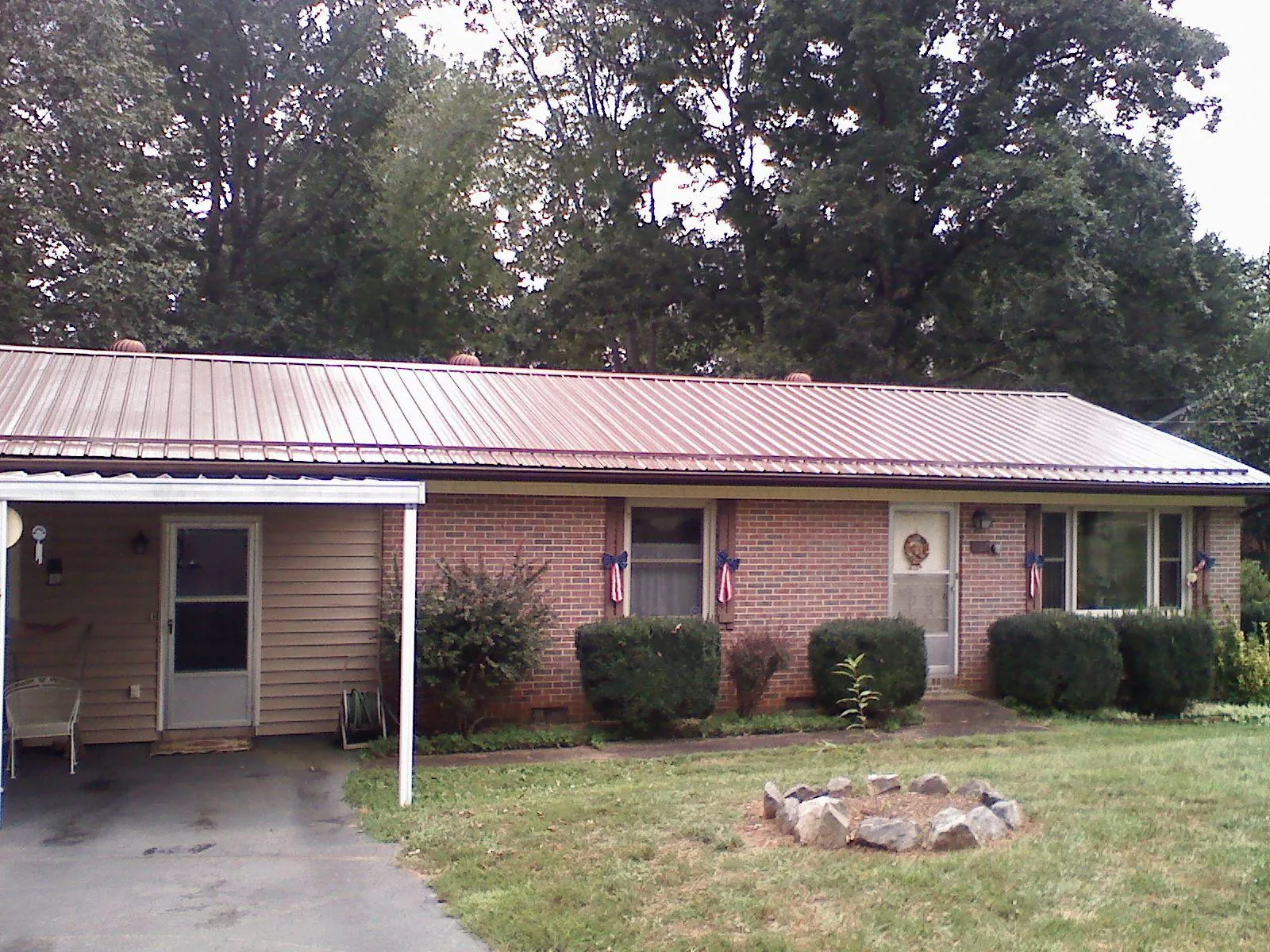 Bronze metal roof and carport on a brick ranch home — Roof Repair work by our crew in Dickerson